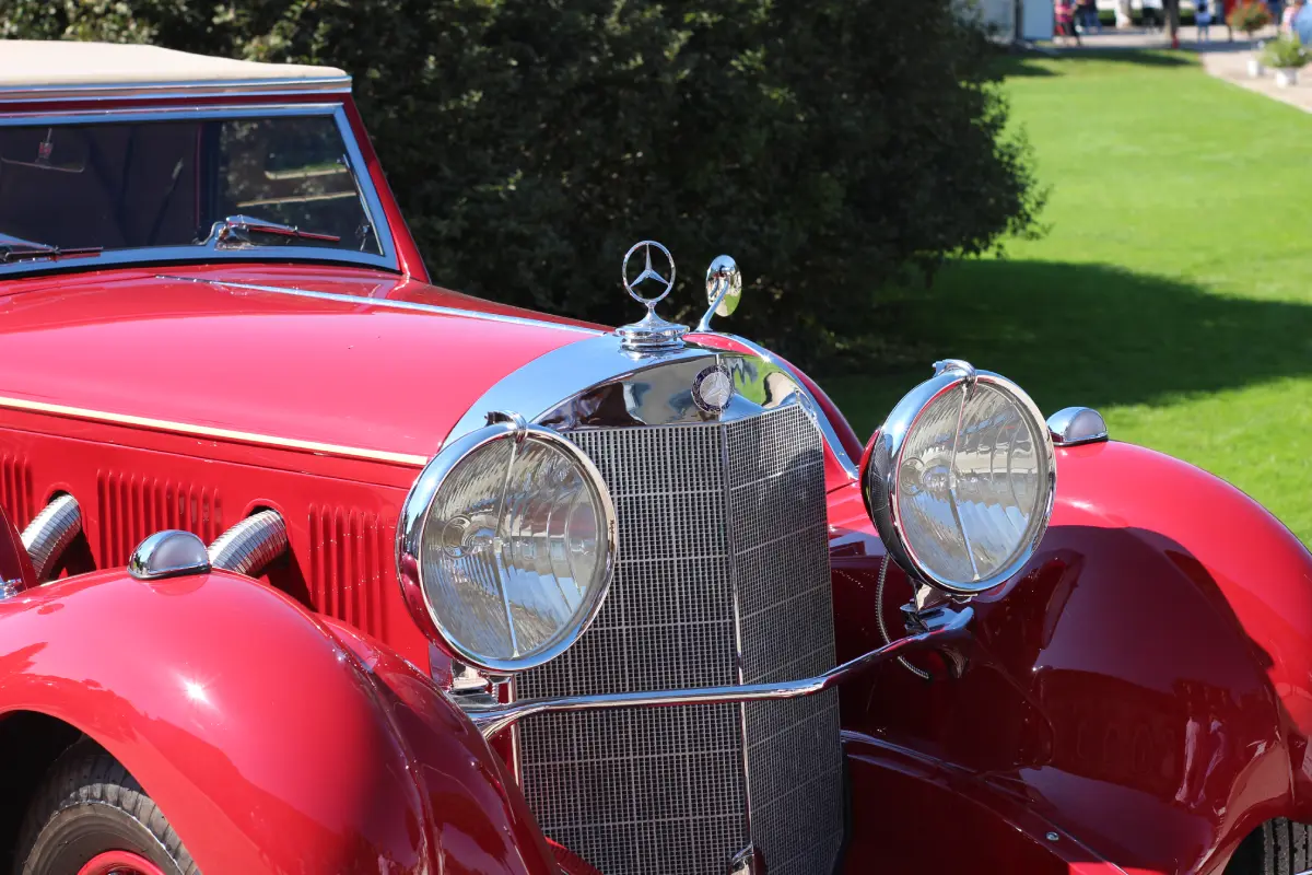 Vorderansicht eines glänzenden roten Oldtimers, ein klassischer Mercedes-Benz mit Chromdetails und markantem Kühlergrill.